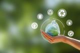 Zero waste. hand holding the earth that plastic bag covering on a green background.