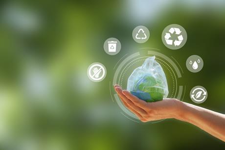 Zero waste. hand holding the earth that plastic bag covering on a green background.